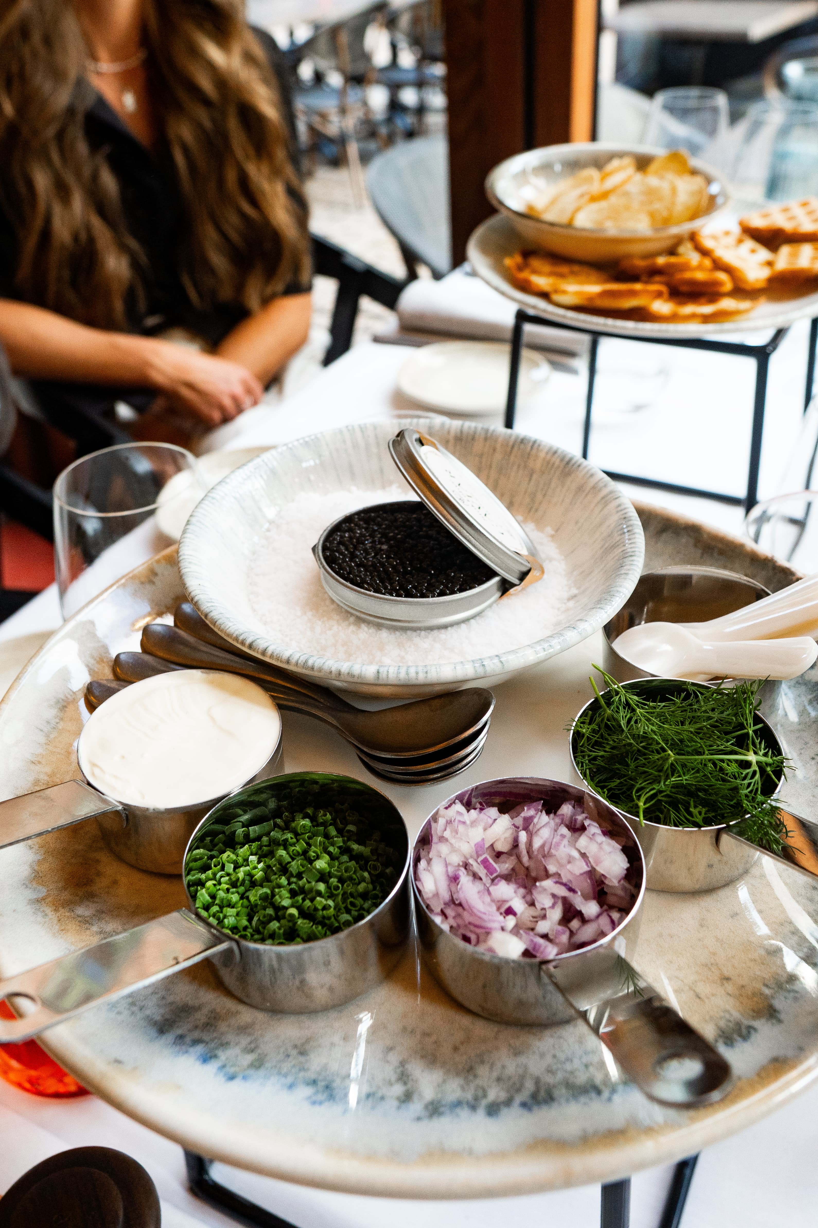 Caviar serveret på is med crème fraîche, purløg, rødløg og dild