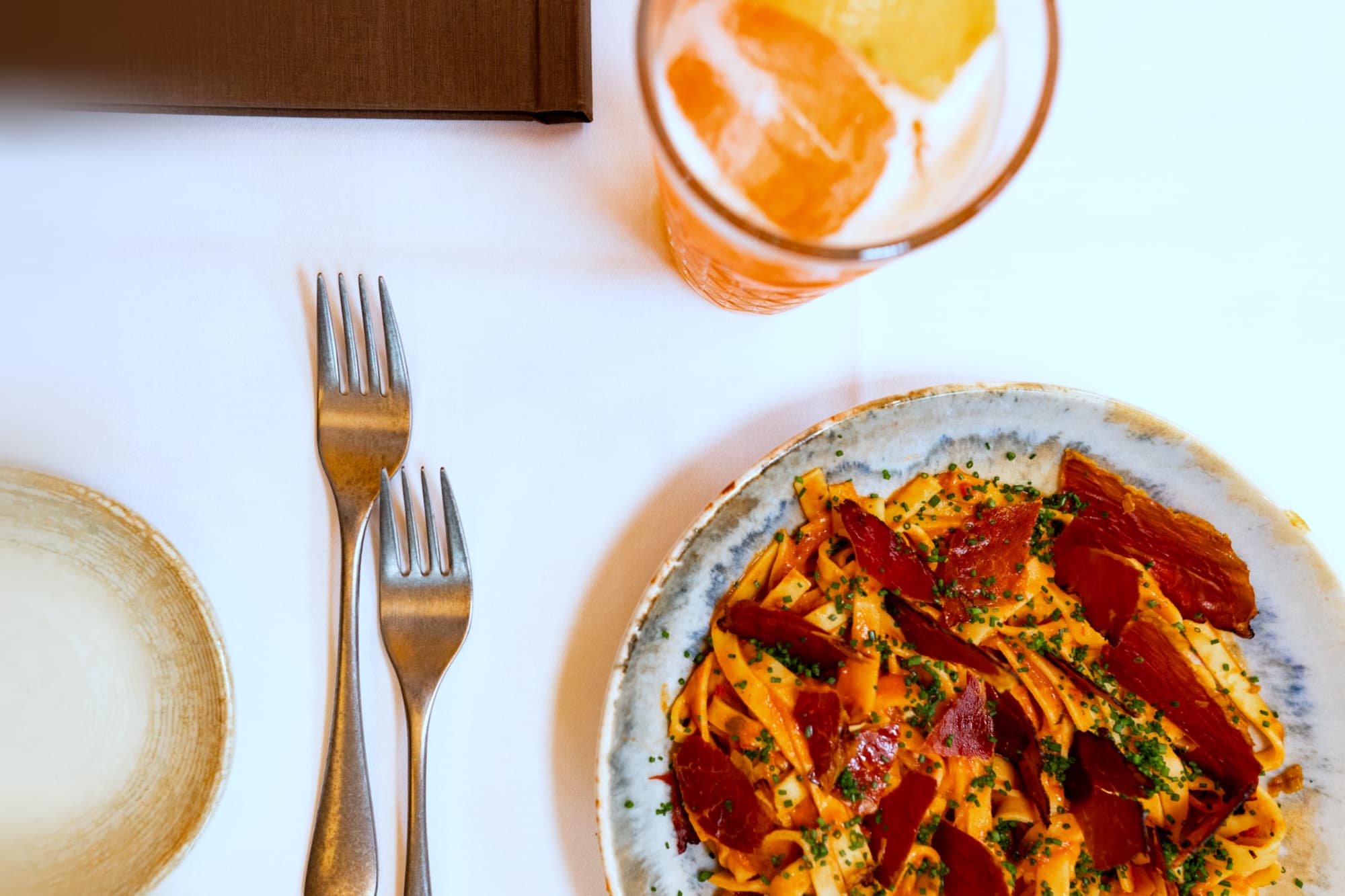 Frisk pasta med spanske skinke og en spritz ved bordet